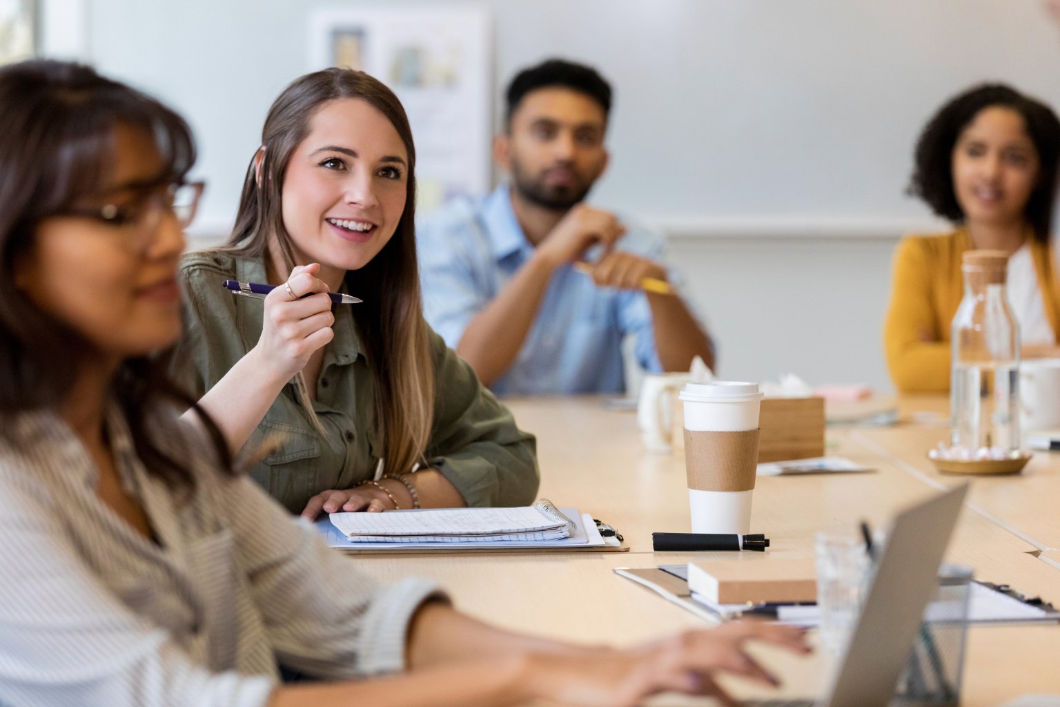 Gruppe von Menschen in einem Meeting, die aktiv miteinander kommunizieren und Ideen austauschen.
