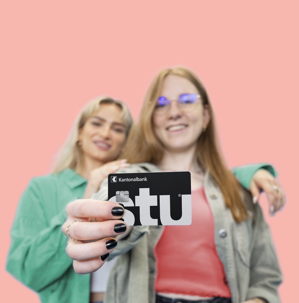 Zwei Frauen mit der BLKB Visa Debit Stu Karte vor pinkem Hintergrund.