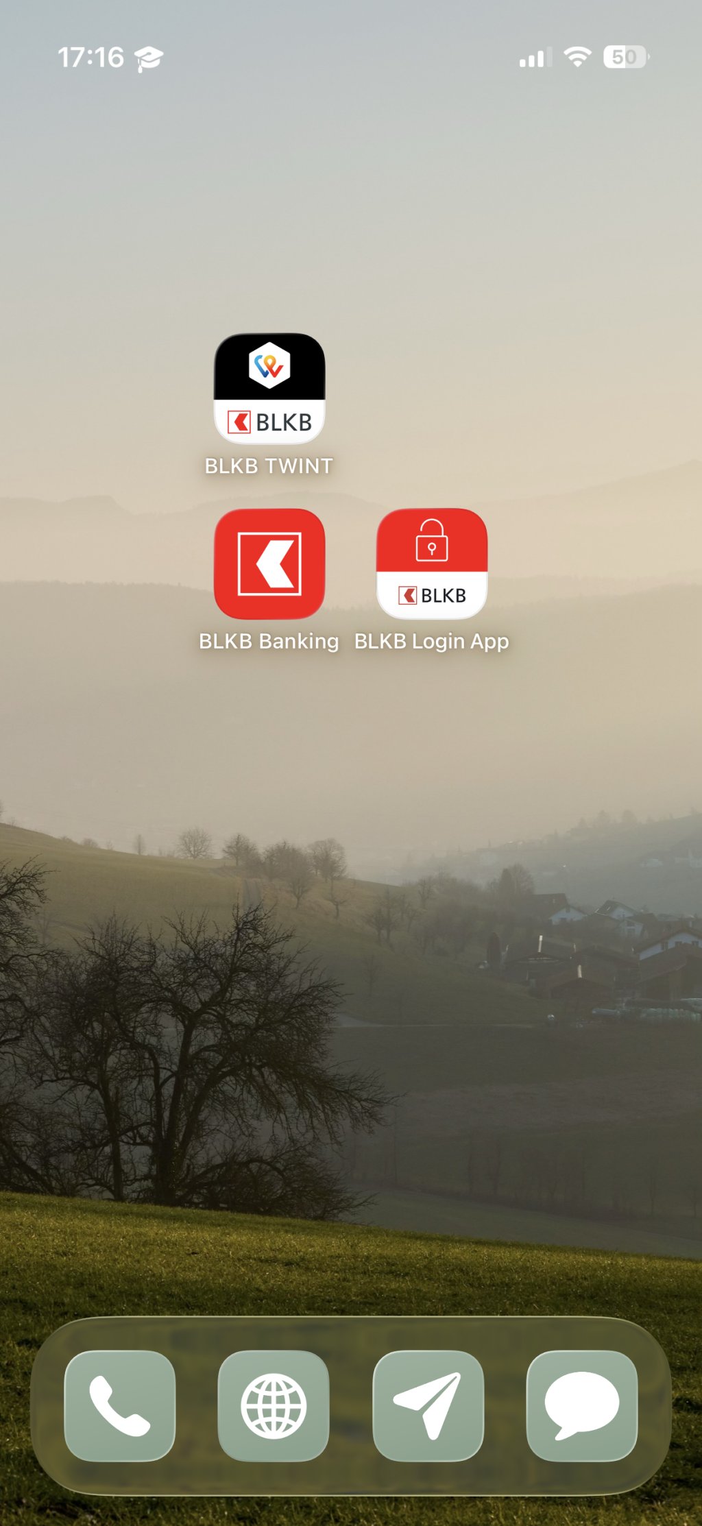 Vier Apps der Basellandschaftlichen Kantonalbank auf dem Handybildschirm vor einer ländlichen Kulisse