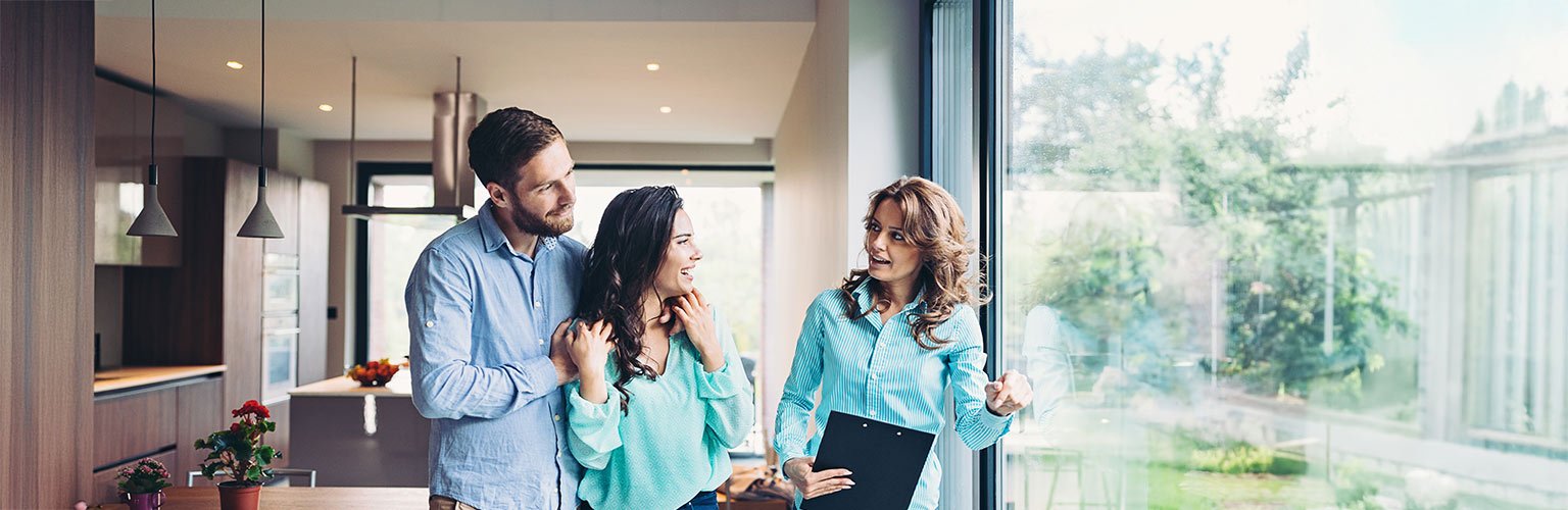 Ein Paar diskutiert Wohnideen mit einer Beraterin in einer hellen, modernen Küche.