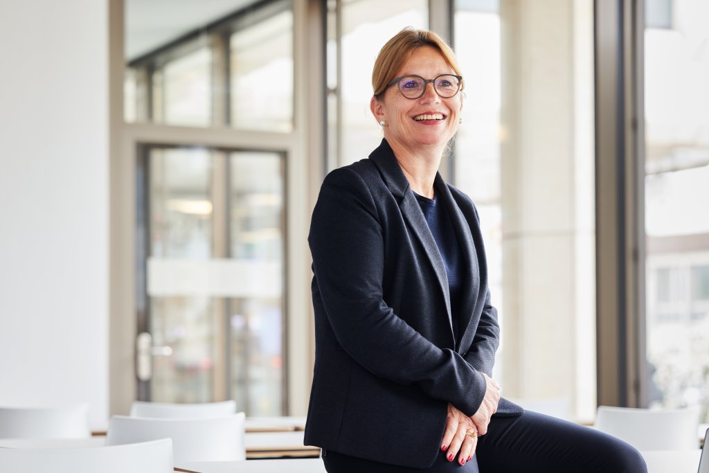 Eine Mitarbeiterin der BLKB in einem modernen Büro mit viel Licht.