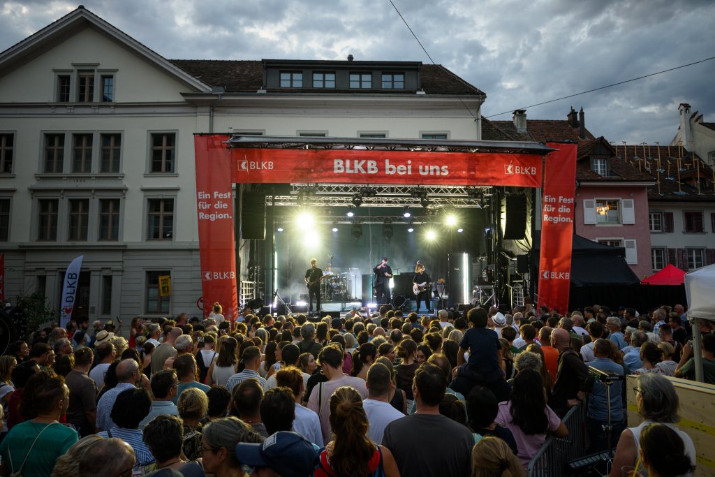 Ein großes Konzert im Freien vor einem historischen Gebäude mit vielen Zuschauern.