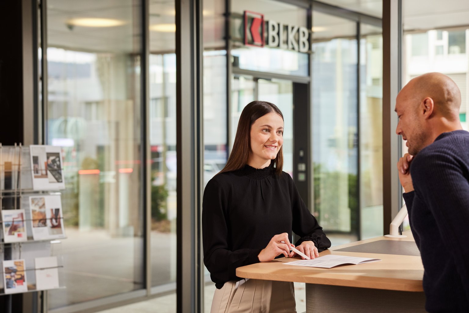 Kundengespräch in der Filiale der Basellandschaftlichen Kantonalbank (BLKB) mit freundlichen Mitarbeitern.
