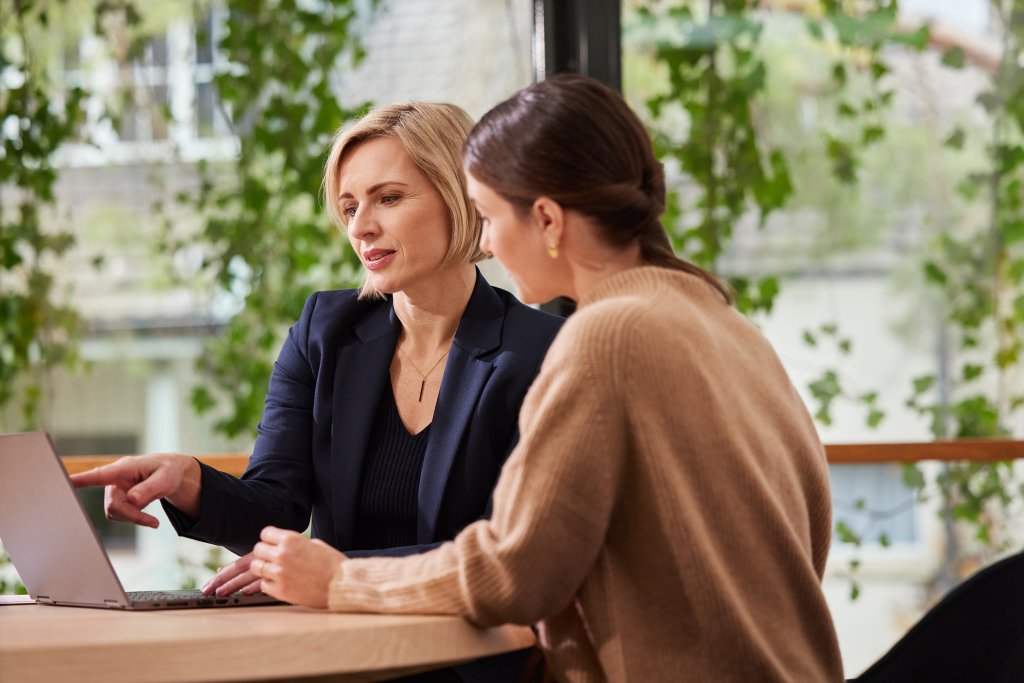 Zwei Frauen im Gespräch bei der BLKB in einer hellen, modernen Atmosphäre.
