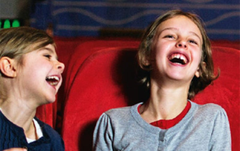 Ein kleiner Junge und ein kleines lachen zusammen im Kino.