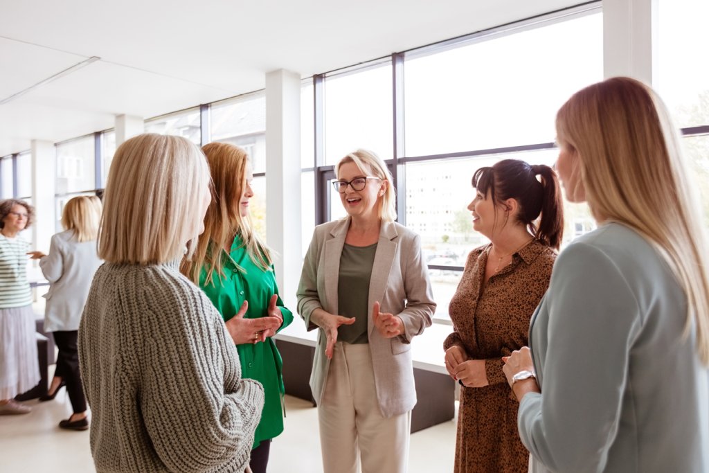 Gruppen von Frauen im Gespräch in heller Bankfiliale der BLKB.