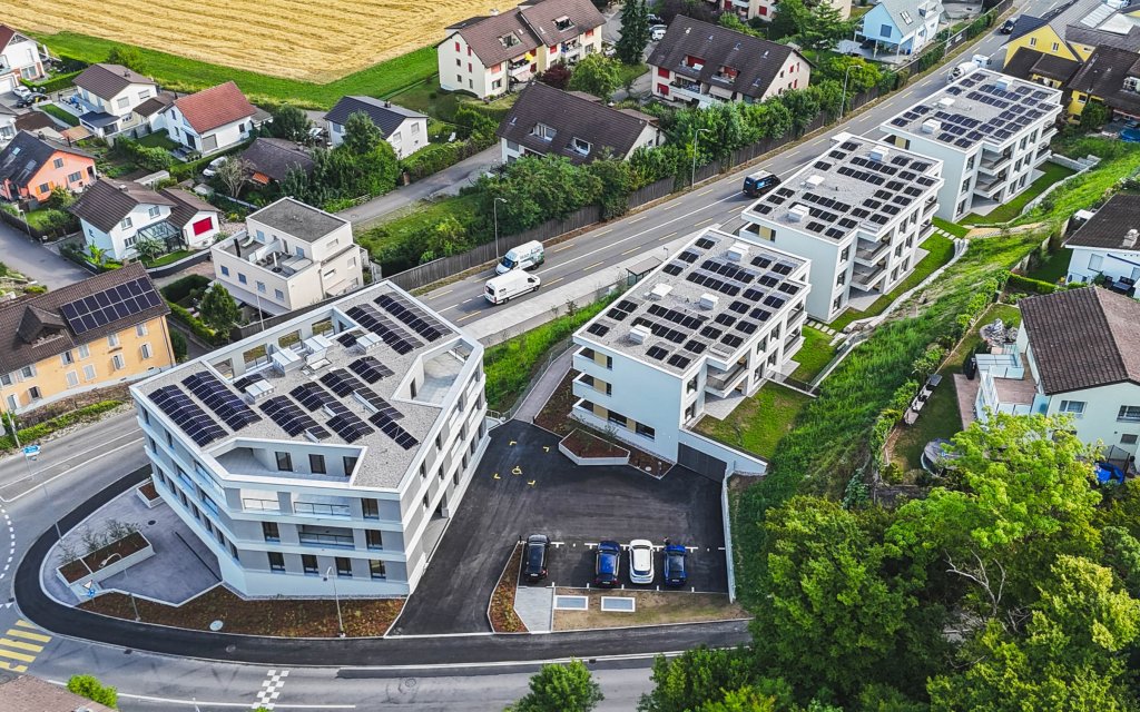 Moderne BLKB Filiale mit Parkplätzen und solarbetriebenen Dächern in der Landschaft