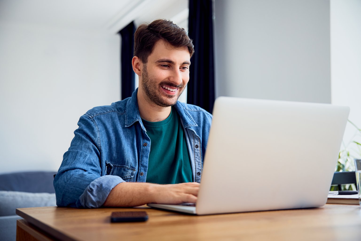 Person arbeitet am Laptop in einem modernen Büro.