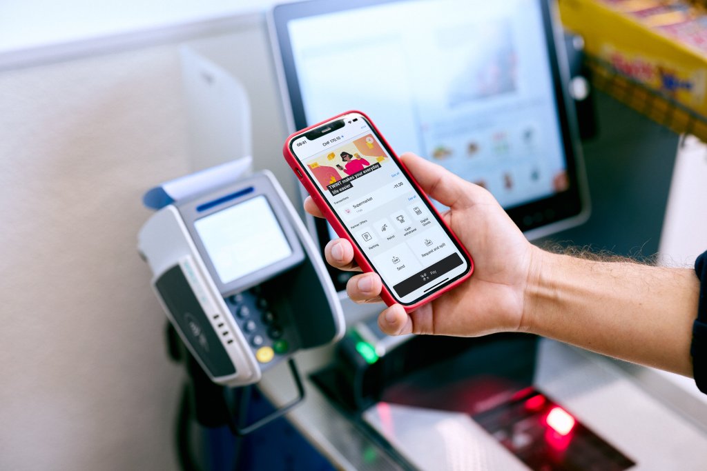 Person bezahlt an einem Self-Checkout im Laden mit Twint