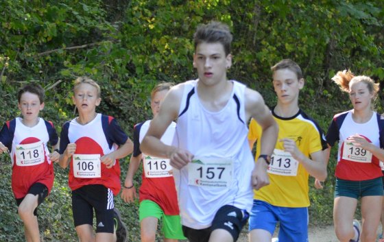 Junge Läufer bei einem Wettkampf in der Natur, motiviert und voller Energie.