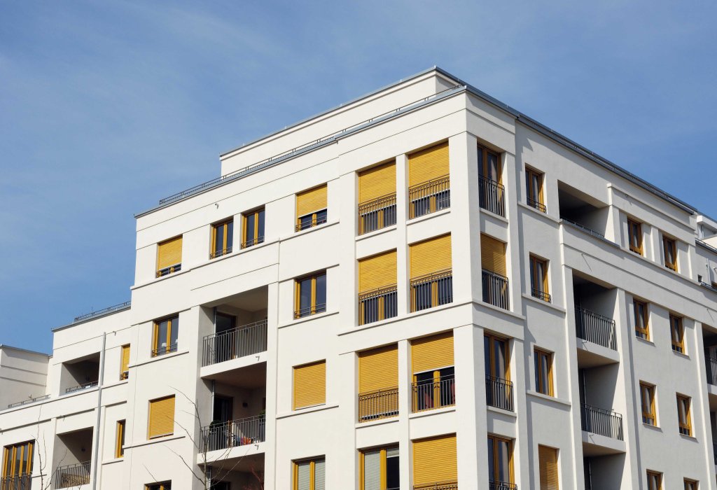 Gebäude mit weisser Aussenwand und gelben Fensterläden.