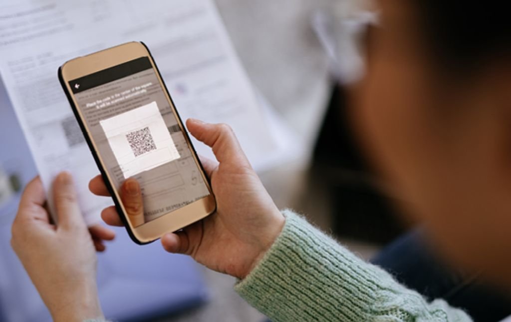 Mann scannt einen QR-Code und zahlt seine Rechnung. aus dem Artikel Die QR-Rechnung – das Zahlen wird einfacher