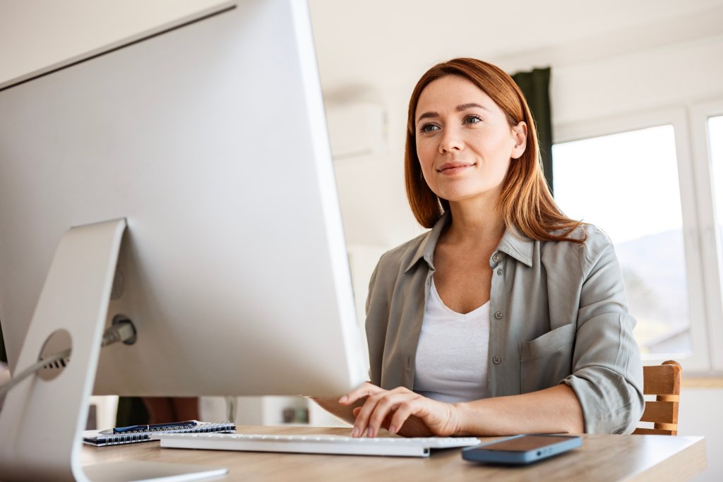 Frau arbeitet am Computer im Büro bei der Basellandschaftlichen Kantonalbank.