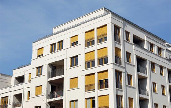 Moderne Wohnbau mit gelben Storen und klarer Architektur in hellem Design.