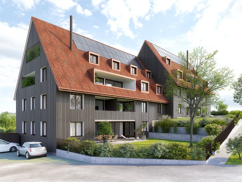 Mehrgeschossiges Haus mit roten Dachziegeln, grünen Bäumen und Parkplatz im Vordergrund am Niedermattweg 2a, 4124 Schönenbuch