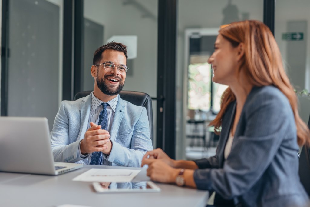 Zwei Personen im Gespräch bei einer Bankberatung in einem modernen Büro.