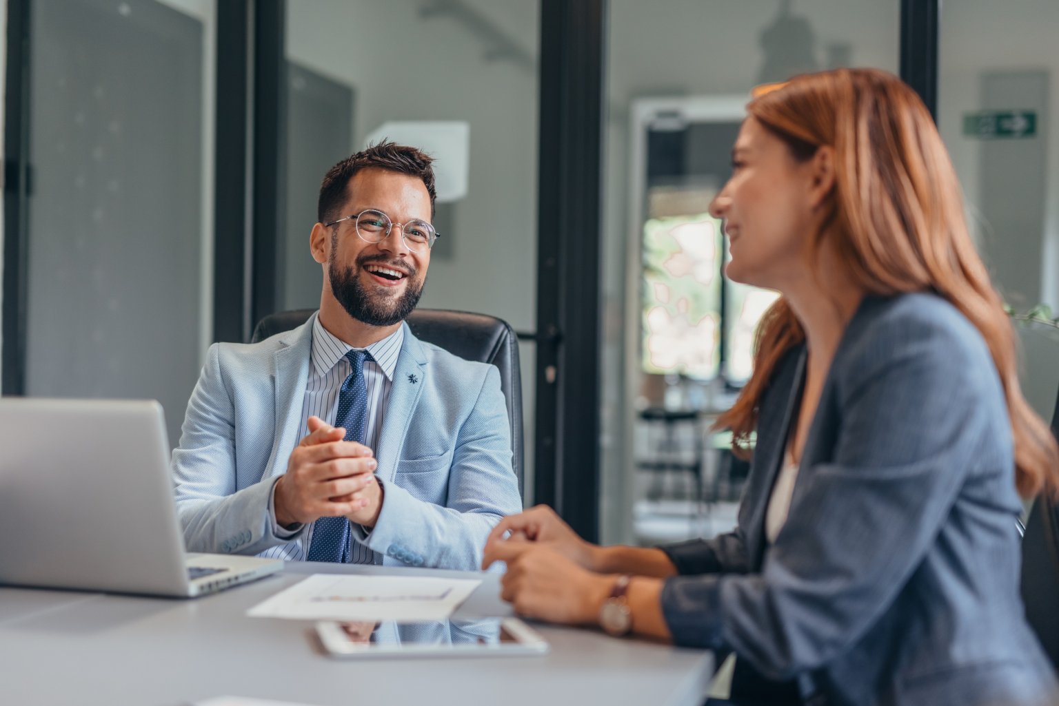 Zwei Personen im Gespräch bei einer Bankberatung in einem modernen Büro. aus dem Artikel Sustainable Asset Management als Profidienstleister