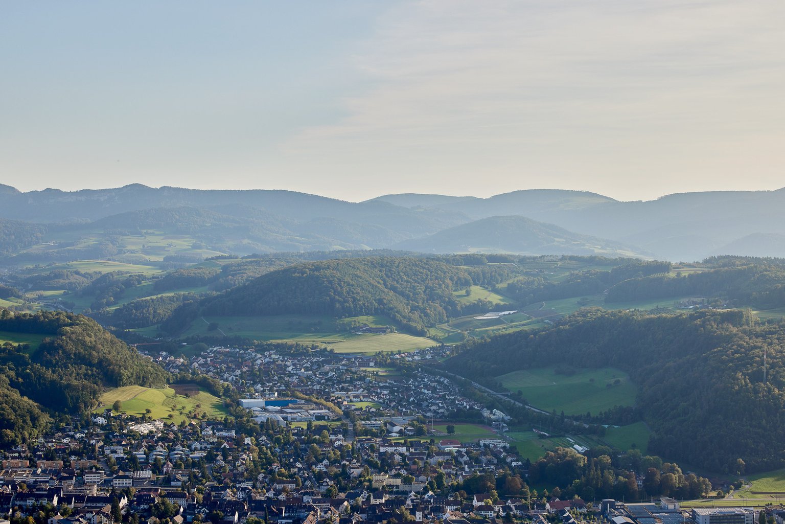 Panorama des Baselland mit sanften Hügeln und idyllischen Dörfern.