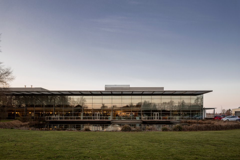 image of exterior buidling covered in glass infront of a lake