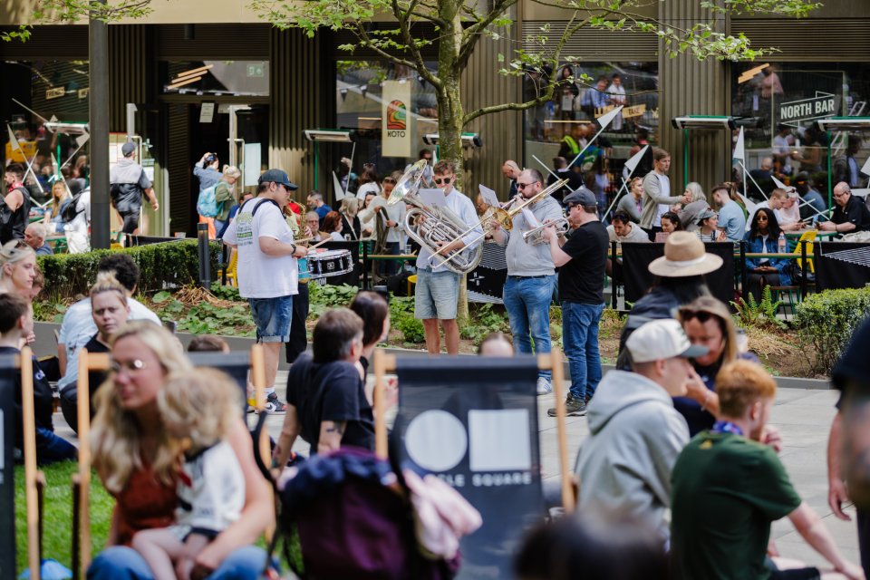 Photo of musicians, families and general public at Symphony Park during the Manchester Marathon fan zone at Circle Square in 2025