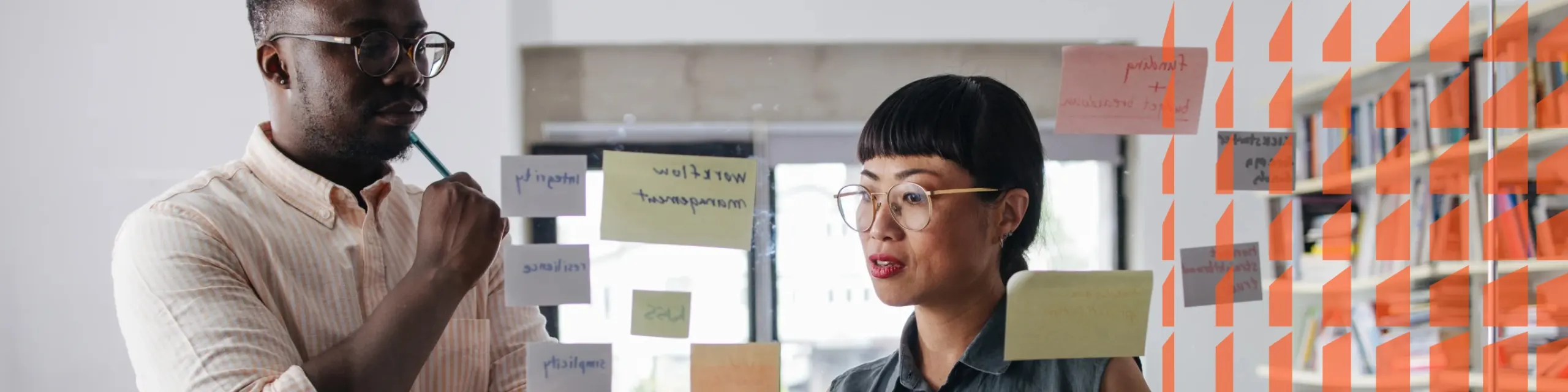 Two persons looking at a board with sticky notes