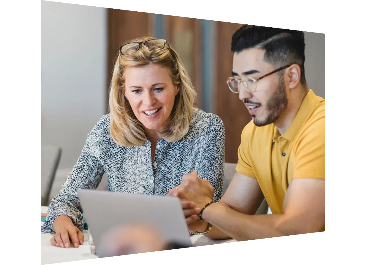 Mature smiling businesswoman collaborating with young employee