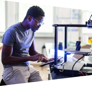 African-American Engineer Working On A 3D Printer