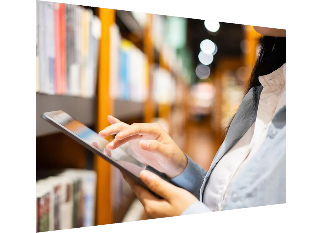Individual searching on a tablet in a library stacks setting