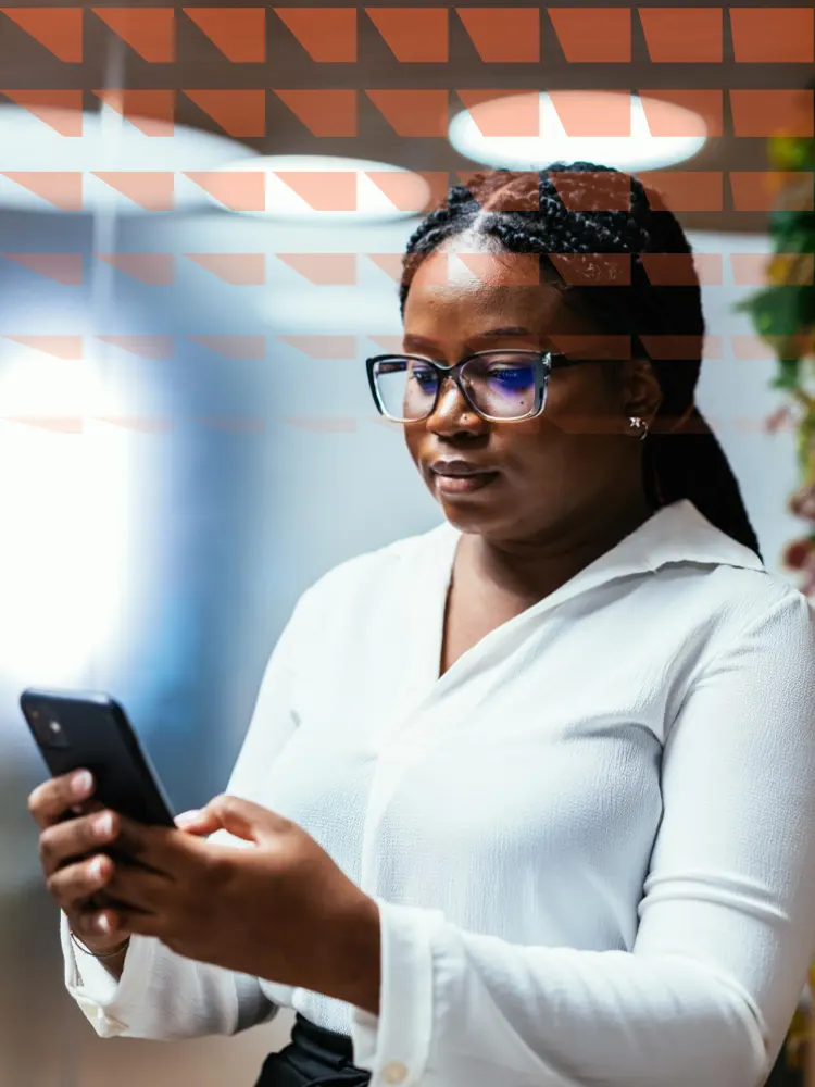 Successful African businesswoman using smart phone in office