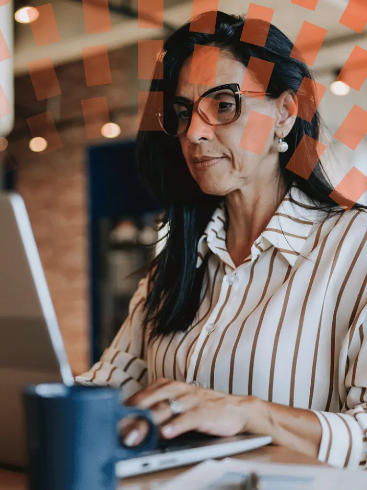Woman on laptop next to window