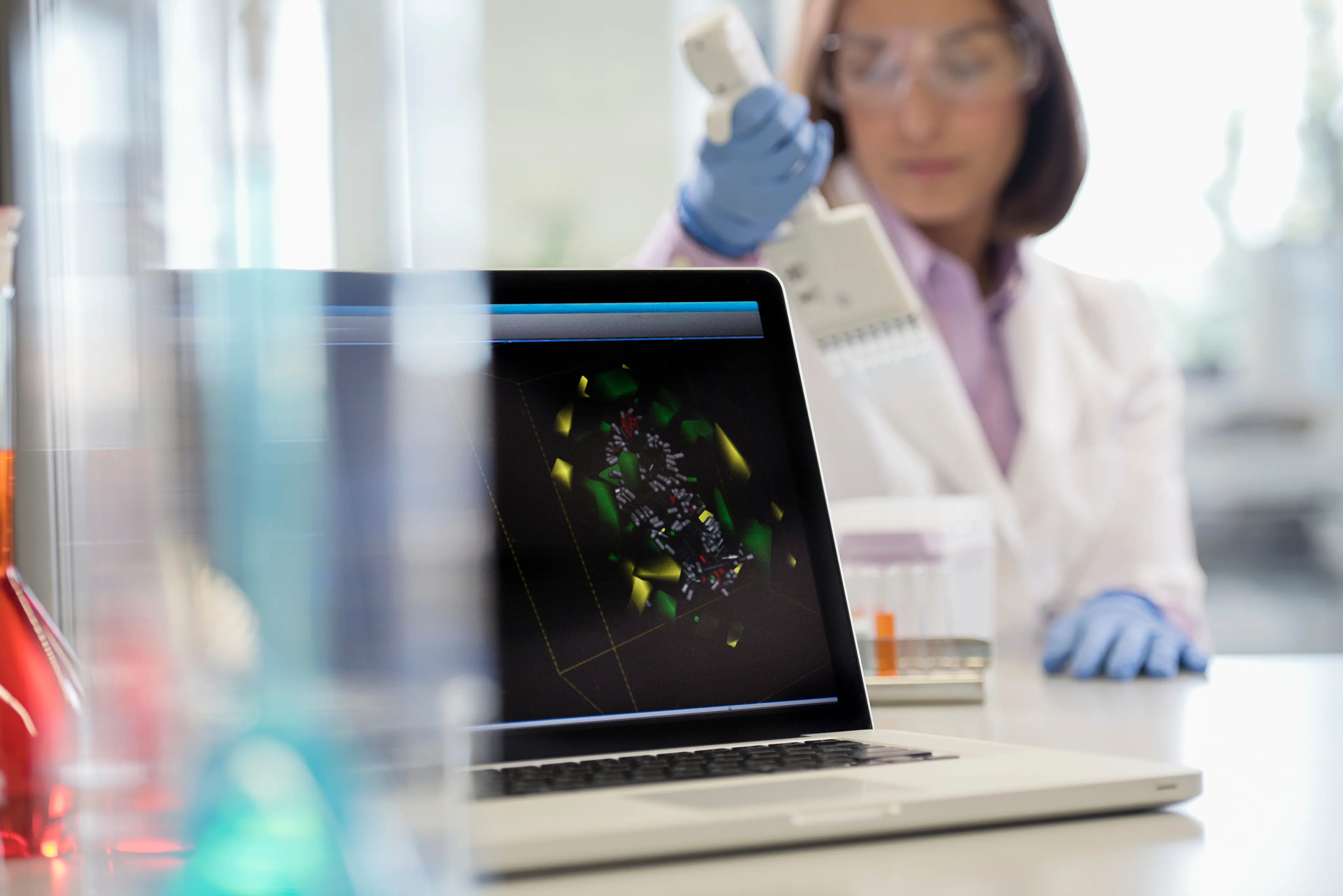 Laptop in laboratory with scientist in background