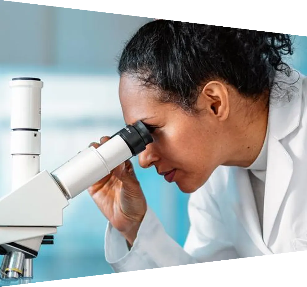 Microbiologist wearing glasses analyzing sample under microscope