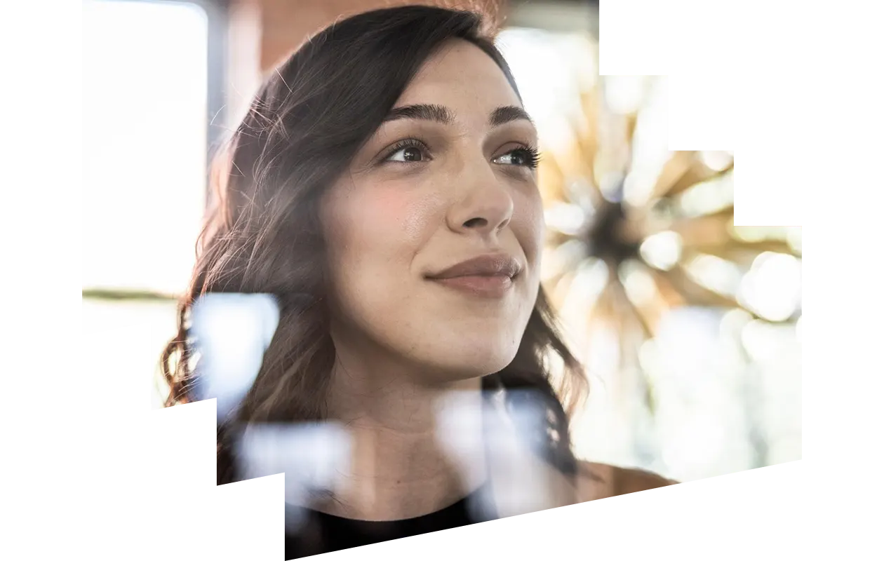 Woman with a laptop and phone smiling at a colleague
