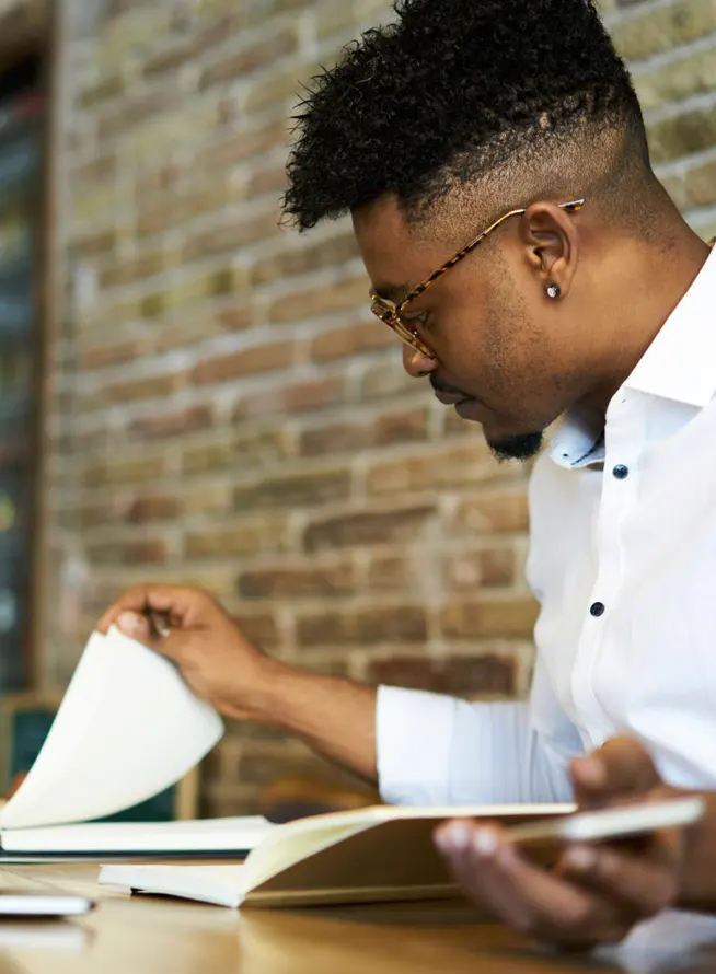 Concentrated Afro-american male author checking his notes