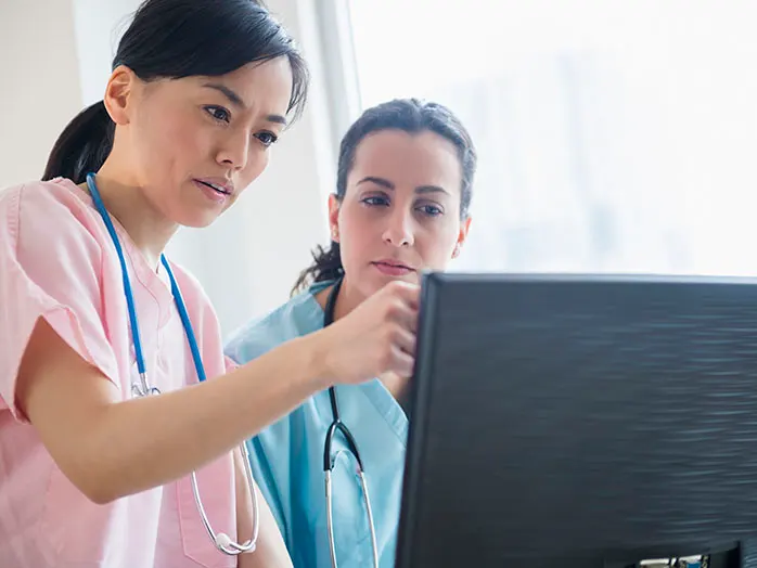 Two nurses review information on a computer