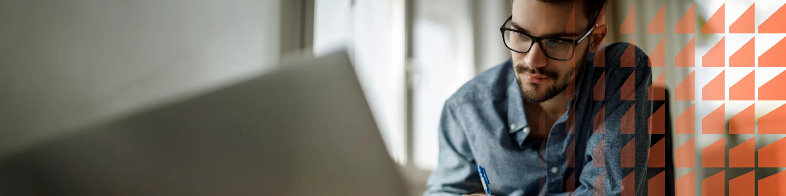 A man looking in front of his laptop