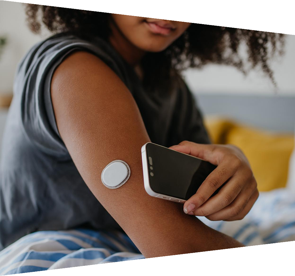 Teenage girl connecting smartphone to monitor blood glucose