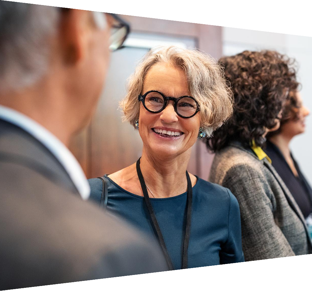 Mature businesswoman chatting with male colleague at conference