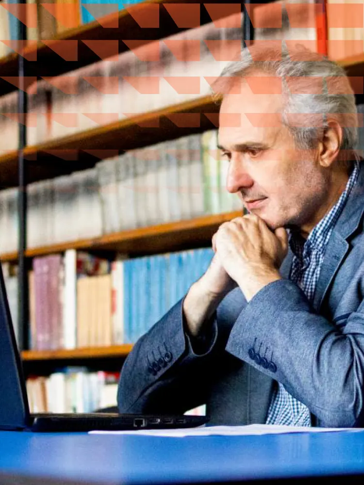 University professor in library looking at student statistics