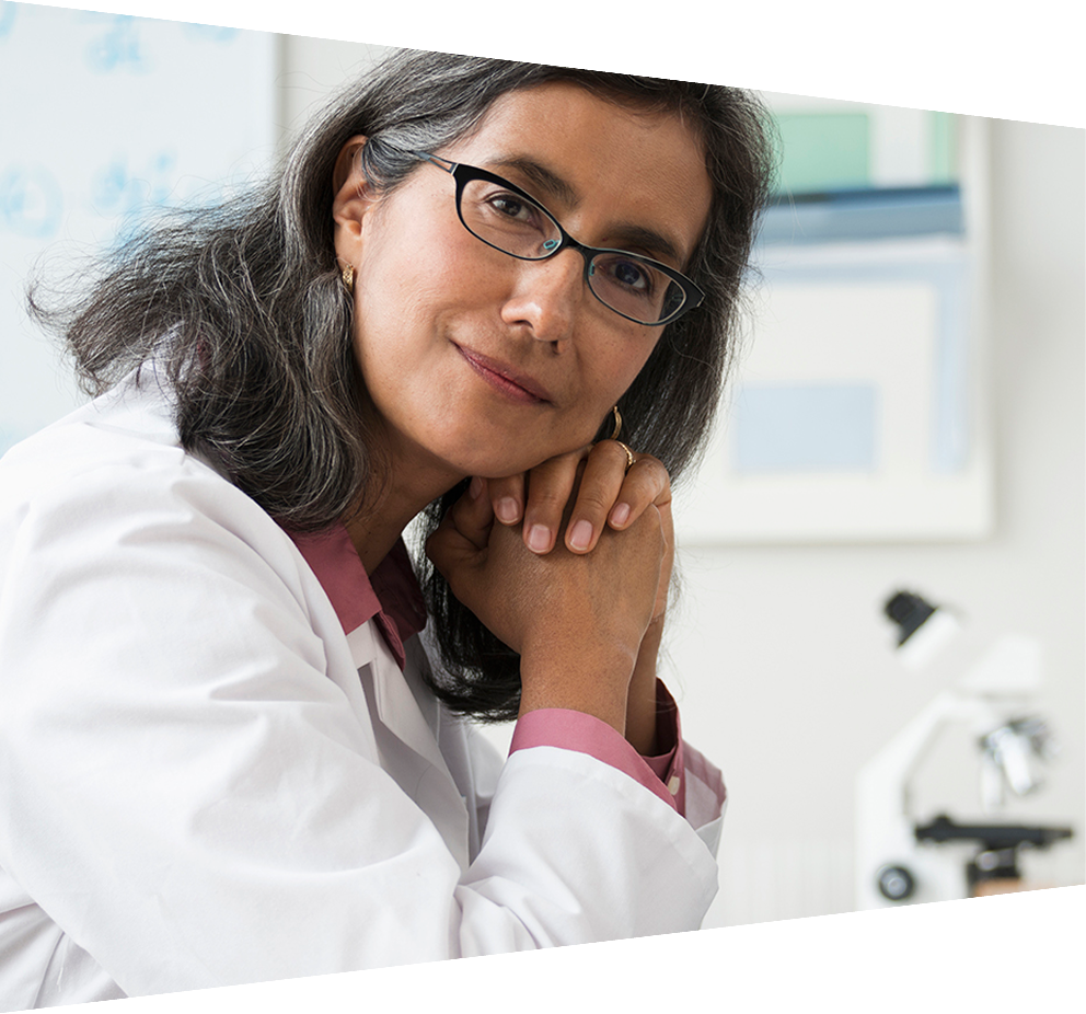 Smiling Hispanic radiologist posing at desk 