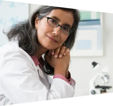 Smiling Hispanic radiologist posing at desk 