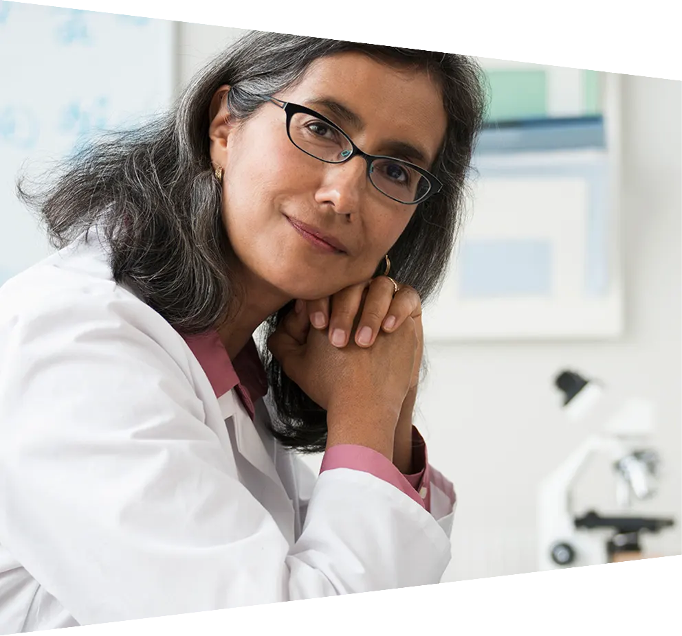 Smiling Hispanic radiologist posing at desk 