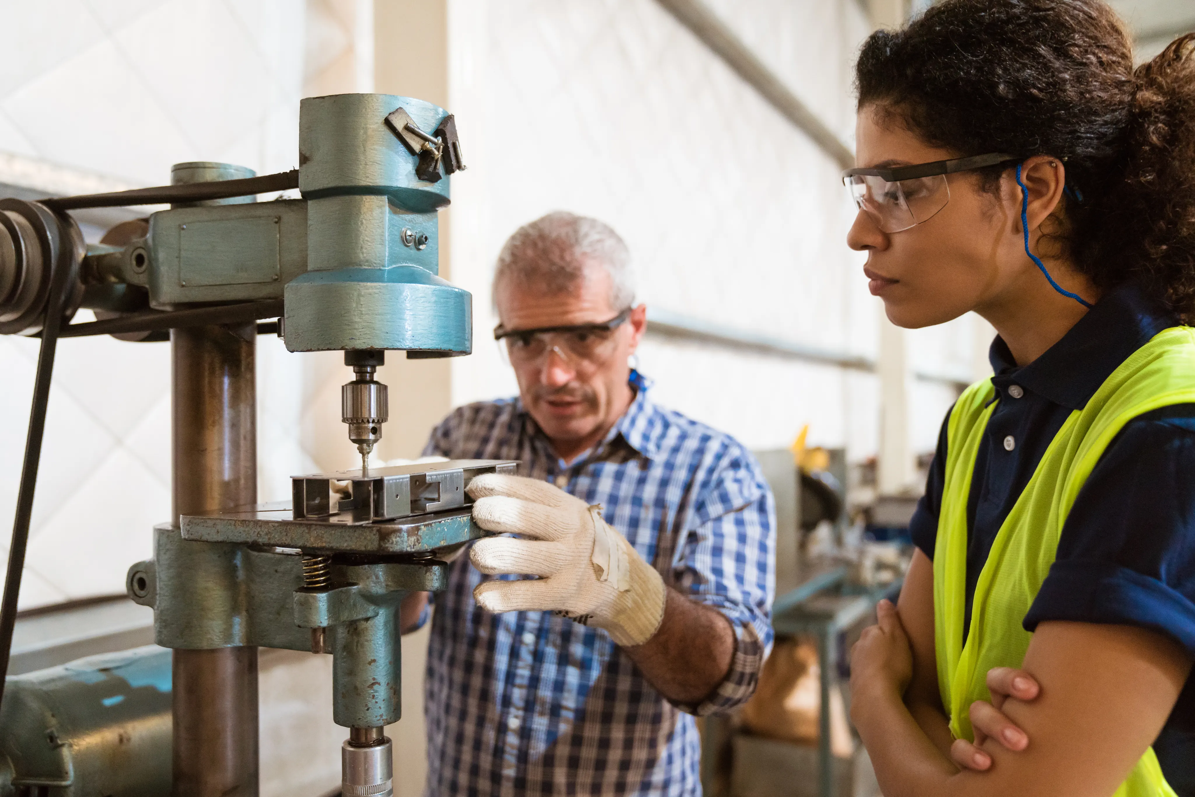 Instructor teaching female trainee in factory