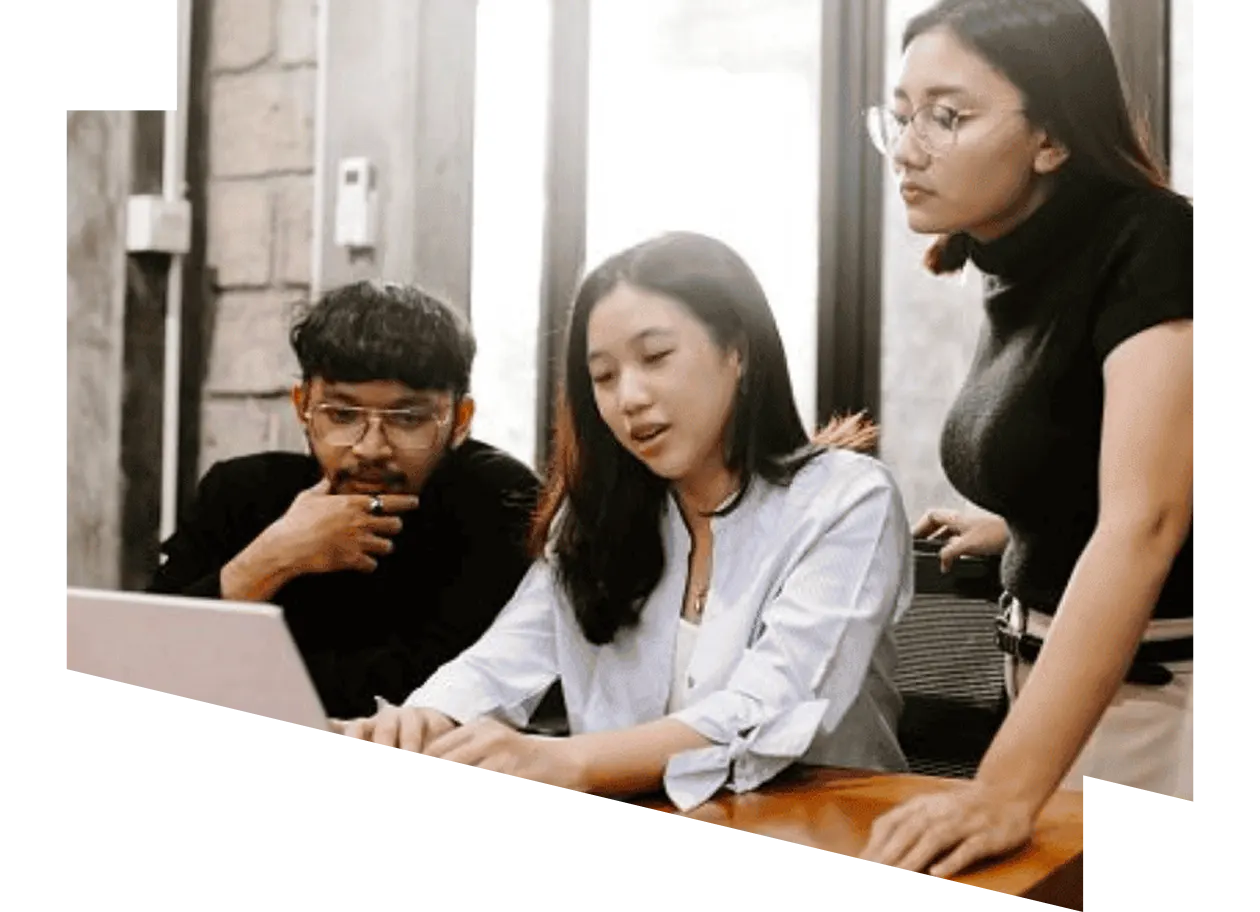 Two young people working with a laptop being guided by a professional