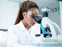 researcher looking into a microscope