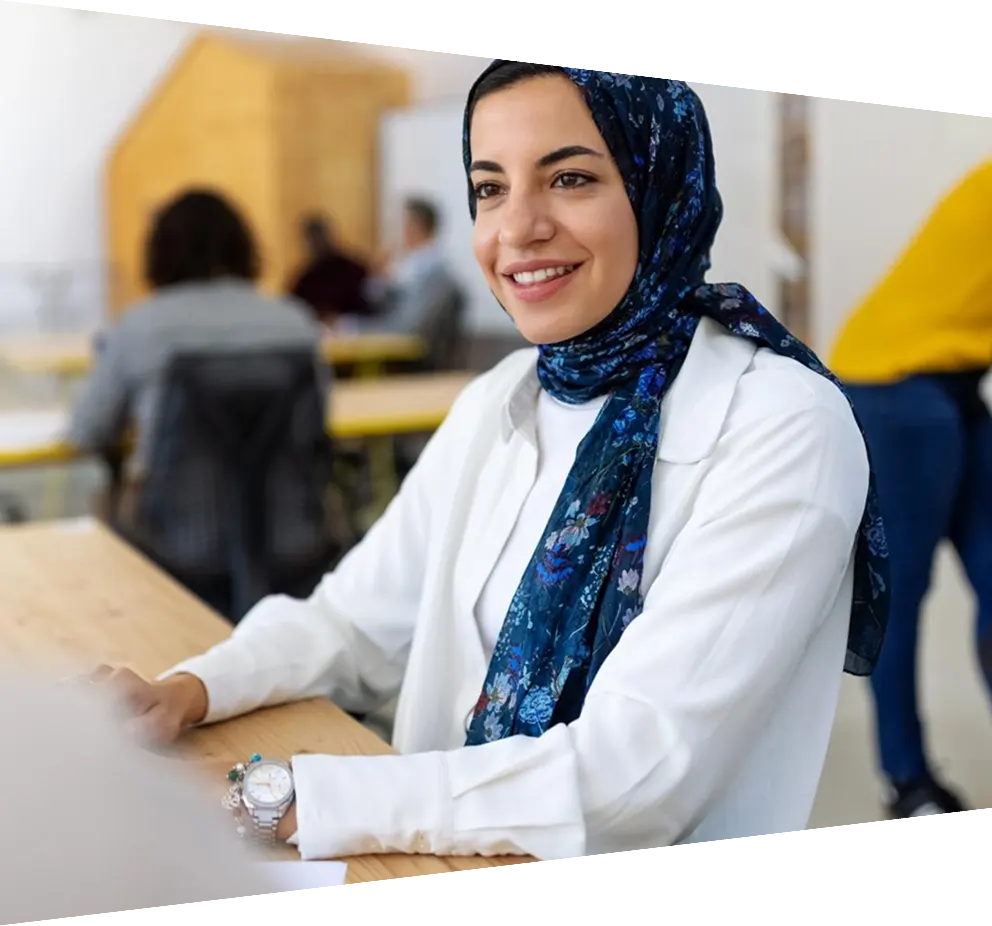 Female professional sitting at desk discussing with a colleague