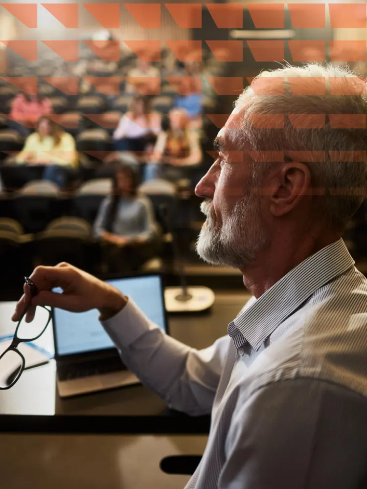 Profile of senior professor during a lecture with his students in background