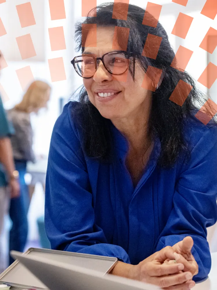 Man and woman engaged in discussion while looking at a tablet together.