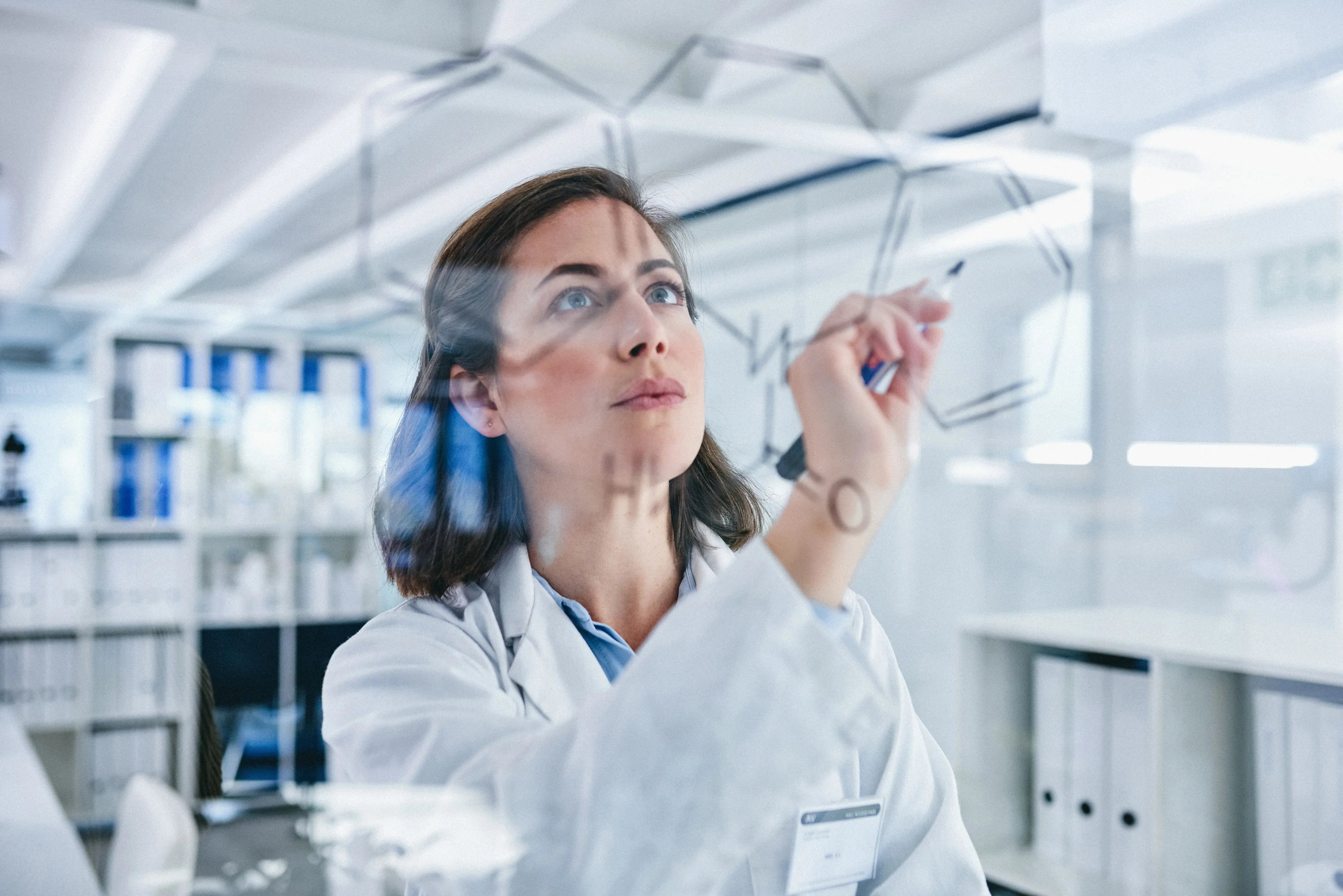 Shot of a scientist solving equations on a glass screen in a laboratory