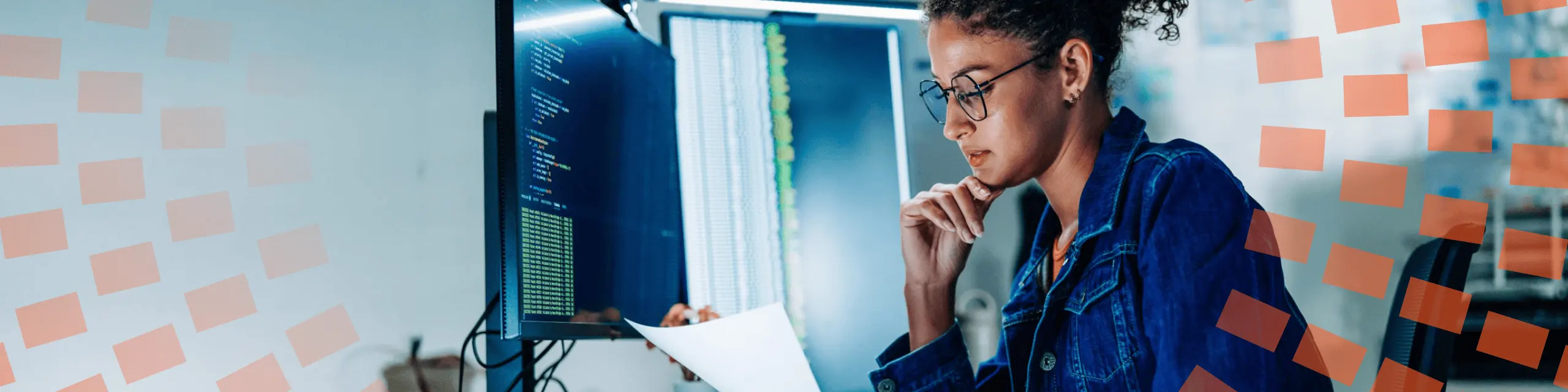 A woman looking in front of her desktop with a blue blouse